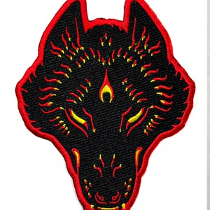 May include: Black wolf head embroidered patch with red and yellow flames. The wolf's eyes are yellow and the mouth is open.