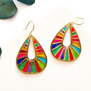 May include: Two teardrop earrings with a gold-coloured frame. Each earring features a stained-glass effect with vibrant colours including red, pink, blue, green, and purple. The earrings have a hook fastening.