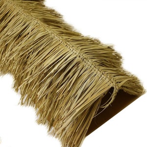 May include: Close-up of a section of natural-colored palm leaf thatch. The thatch is woven together, with long, thin leaves extending outward. The material appears dry and is likely used for roofing or decorative purposes.