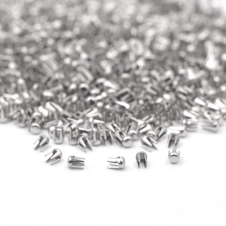 May include: A large pile of silver metal rivets, with a few close-up shots of individual rivets.