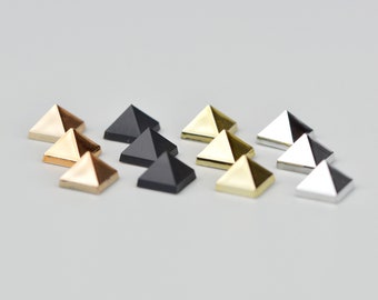 May include: Assortment of pyramid-shaped studs in gold, silver, and black.