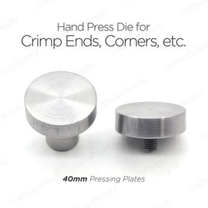 Puede incluir: Dos matrices de prensa de mano de metal plateado para crimpado de extremos, esquinas y otras formas. Las matrices tienen un diámetro de 40 mm y un acabado liso y pulido.