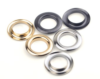 May include: Five metal eyelets in different finishes: gold, silver, and black. The eyelets are arranged in a semi-circle.