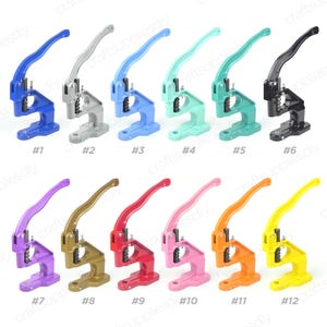 May include: A selection of twelve manual press machines in diverse colours, such as blue, silver, light blue, teal, black, purple, gold, red, pink, orange, and yellow. Each machine features a lever and base, suitable for crafting.