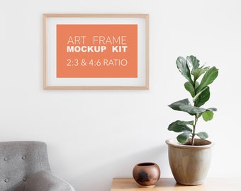 May include: A wooden picture frame mockup kit with a light orange background. The text on the frame reads "Art Frame Mockup Kit 2:3 & 4:6 Ratio". The frame is hanging on a white wall with a potted plant and a small brown vase on a wooden table in the foreground.