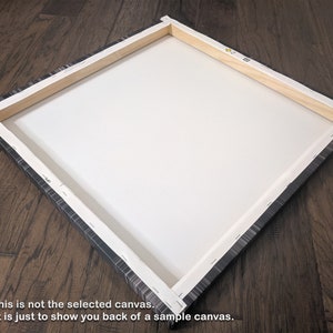 May include: The back of a stretched canvas with a wooden frame. The canvas is wrapped around the frame and stapled in place. The frame is made of natural wood.
