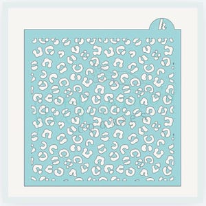 May include: A light blue stencil with a leopard print pattern. The stencil features a repeating design of white leopard spots. The top right corner has a small tab with the letter "k".