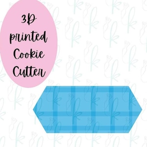 May include: A 3D printed cookie cutter in a blue plaid design. The text "3D printed Cookie Cutter" is displayed on a pink oval. The background is white with a repeating pattern.