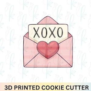May include: A pink envelope cookie cutter with a red heart and a note that says "XOXO". The cookie cutter is 3D printed. The design is perfect for Valentine's Day or other romantic occasions.