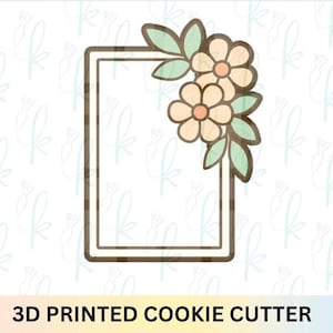 Può includere: Tagliapasta stampato in 3D con un telaio rettangolare e un motivo floreale. I fiori sono color pesca con contorni marroni e le foglie sono verde chiaro. Il testo "3D PRINTED COOKIE CUTTER" è in basso.