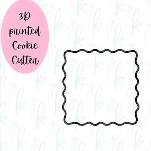 May include: A black, square cookie cutter with a wavy edge. A pink oval to the left reads "3D printed Cookie Cutter" in black script. The background is white with a light blue pattern.