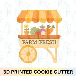 May include: A 3D printed cookie cutter in the shape of a farm stand. The stand has an orange and white striped awning, a wooden cart, and is filled with vegetables and a potted flower. The text "FARM FRESH" is displayed on the front.