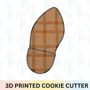 Puede incluir: Un cortador de galletas impreso en 3D con forma de zapato. El cortador con forma de zapato tiene un patrón de cuadros marrones y un contorno oscuro. El texto "3D PRINTED COOKIE CUTTER" está en la parte inferior de la imagen.