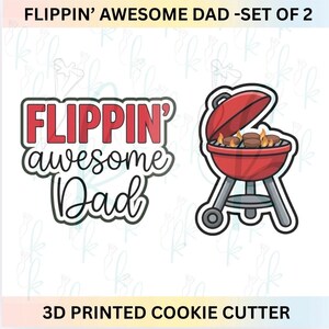 Puede incluir: Un juego de dos cortadores de galletas impresos en 3D. Uno presenta el texto FLIPPIN' awesome Dad en letras rojas y negras. El segundo representa una parrilla de carbón roja con tapa, que contiene hamburguesas marrones y llamas naranjas.