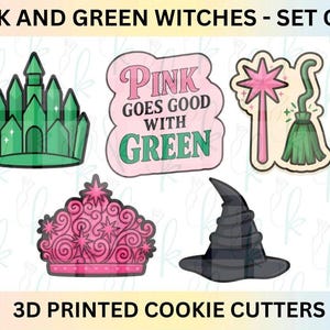 Puede incluir: Juego de 5 cortadores de galletas con temática de brujas rosas y verdes. Incluye un castillo verde, un letrero rosa con el texto "PINK GOES GOOD WITH GREEN", una varita rosa y una escoba verde, una tiara rosa y un sombrero de bruja negro.