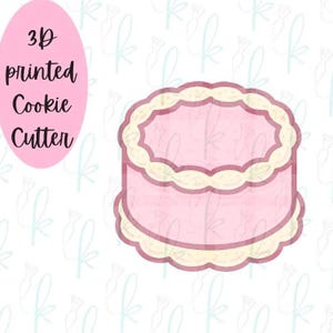 May include: A pink 3D printed cookie cutter shaped like a cake with a scalloped design. The text "3D printed Cookie Cutter" is in a pink oval on the left. Ideal for baking.