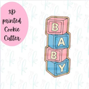May include: A 3D printed cookie cutter shaped like a vertical stack of four square blocks. The blocks alternate between pink and blue colors, each featuring a cream-colored letter on the front face, spelling out the word BABY in sequence.