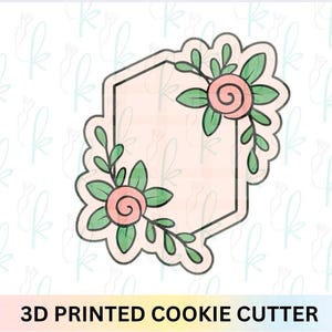Puede incluir: Cortador de galletas impreso en 3D con forma de hexágono con detalles florales. El cortador presenta dos rosas rosas con hojas y tallos verdes. El texto "3D PRINTED COOKIE CUTTER" está en la parte inferior.