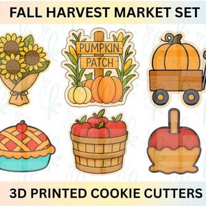 Może przedstawiać: Zestaw wycinarek do ciasteczek drukowanych w 3D o tematyce jesiennych zbiorów. Zestaw zawiera bukiet słoneczników, znak 'Pumpkin Patch', dynię w wózku, ciasto, kosz jabłek i karmelizowane jabłko. Tekst: 'FALL HARVEST MARKET SET' i '3D PRINTED COOKIE CUTTERS'.