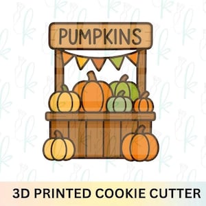 Może przedstawiać: Wykrawacz do ciastek drukowany w 3D przedstawiający drewniany stragan z dyniami z napisem "PUMPKINS" na górze. Stragan jest wypełniony pomarańczowymi, żółtymi i zielonymi dyniami. Ozdobne chorągiewki wiszą nad dyniami. Tekst "3D PRINTED COOKIE CUTTER" znajduje się na dole.