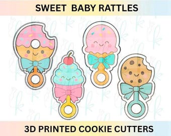 May include: Four 3D printed cookie cutters shaped like baby rattles with sweet treat designs. The set includes a donut, a cupcake with a cherry, an ice cream cone, and a chocolate chip cookie, all featuring smiling faces and bows.