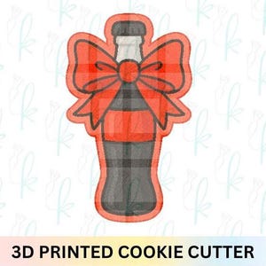 May include: A 3D-printed cookie cutter in the shape of a soda bottle with a red plaid bow. The bottle is black and gray with a red plaid bow. The text "3D PRINTED COOKIE CUTTER" is at the bottom.