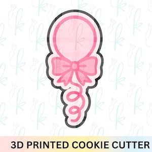 May include: A pink balloon-shaped cookie cutter with a bow and a curly ribbon. The outline is black, and the text "3D PRINTED COOKIE CUTTER" is at the bottom. The background is white with a repeating pattern.