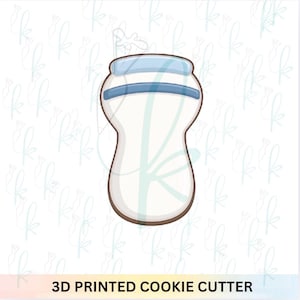 Może przedstawiać: Zestaw trzech ceramicznych kubków z nakrapianym, matowym wykończeniem. Kubki są w odcieniach kremu, jasnoszarym i ciemnoszarym. Każdy kubek ma prosty, minimalistyczny design i zaokrąglony uchwyt.