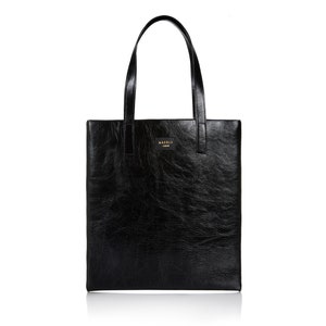 以下が含まれることがあります： 「MABLE LONDON」と刻まれた金色のロゴが付いた黒い革製のトートバッグです。