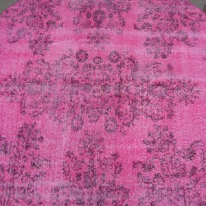 May include: A pink round rug with a faded floral pattern in a darker shade of pink.