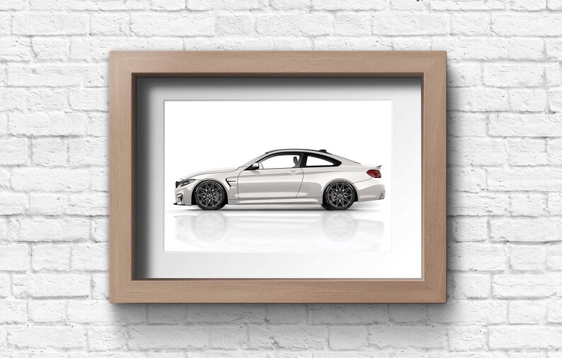 May include: A white coupe car with black wheels and a black interior is shown in profile against a white background. The car is framed in a light wood frame.