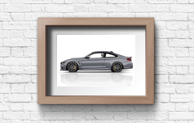 May include: A framed photograph of a silver grey sports car on a white background. The car is in profile view, with the driver's side facing the viewer.