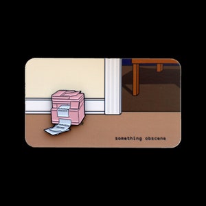 May include: A pink printer with paper spilling out of it, lying on the floor of a room with a wooden table leg in the background. The text "something obscene" is printed below the printer.