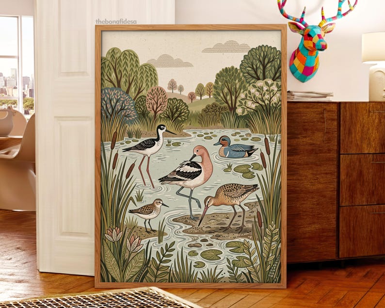 Puede incluir: Una l&aacute;mina de arte enmarcada que presenta una ilustraci&oacute;n detallada de un humedal con cuatro especies de aves distintas, incluyendo una cig&uuml;e&ntilde;uela, una avoceta, un correlimos peque&ntilde;o y un pato azul entre juncos y nen&uacute;fares.