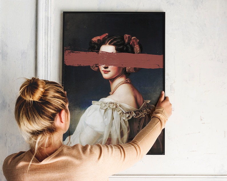 May include: A framed portrait of a woman with a pink ribbon in her hair. A horizontal pink brushstroke covers her eyes. The woman is wearing a white dress with lace trim.