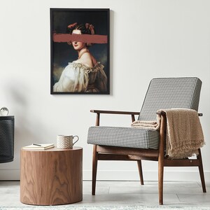 May include: A black and white checked armchair with a brown throw blanket, a wooden side table with a cup and a notebook, and a framed print of a woman with a red stripe over her eyes.