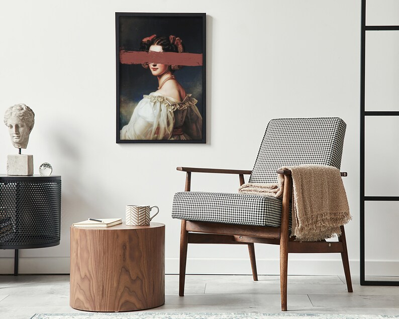 May include: A black and white checked armchair with a brown throw blanket, a wooden side table with a cup and a notebook, and a framed print of a woman with a red stripe over her eyes.
