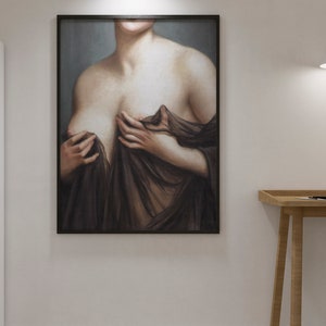 May include: A framed painting depicting a woman's torso, she is wearing a sheer black fabric draped over her shoulders. The painting is set against a light grey background.