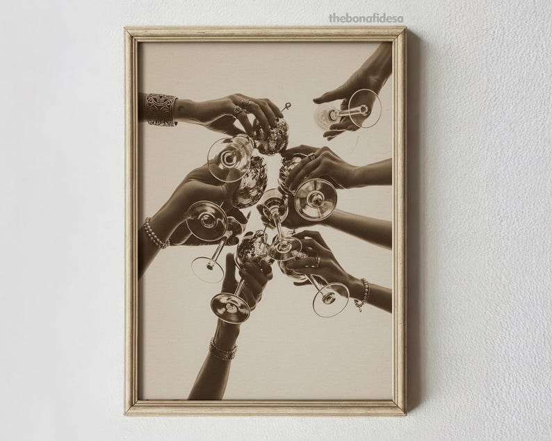 May include: Sepia-toned framed print featuring multiple hands holding champagne glasses in a celebratory toast. The image captures a moment of togetherness, with the glasses raised in a circle. The print has a vintage aesthetic.
