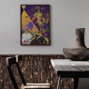 May include: A framed abstract floral print with a yellow, purple, and green color scheme hangs on a white wall above a wooden table and a woven basket.