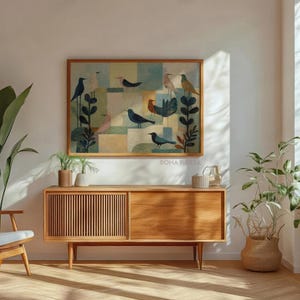 May include: A framed artwork featuring stylized birds in shades of blue, green, and brown. The artwork hangs above a wooden cabinet with a slatted door. The room is decorated with plants and a wooden chair.