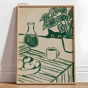 Può includere: Una stampa artistica incorniciata con un'illustrazione stravagante. Un gatto verde sbircia da dietro un tavolo con una tovaglia a righe. Sono raffigurati anche un vaso, libri, una ciotola di frutta, una tazza e una pianta in vaso. L'opera è firmata "bonafidesa".