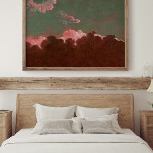 May include: A framed painting of a pink and green sunset over a dark forest. The painting is hanging on a white wall above a wooden bed with white bedding and pillows.
