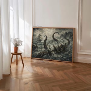 May include: A framed print depicting a dramatic sea battle. The artwork shows a ship and a small boat under attack by a giant octopus in stormy waters. The print is in a wooden frame and is displayed on a wooden floor.