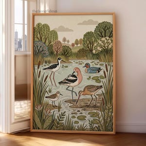 Puede incluir: Una l&aacute;mina de arte enmarcada con una ilustraci&oacute;n estilizada de varias aves en un humedal. La escena incluye una cig&uuml;e&ntilde;uela, una avoceta de color rosa parduzco, un peque&ntilde;o correlimos, una agachadiza marr&oacute;n y un pato azul entre juncos y nen&uacute;fares.
