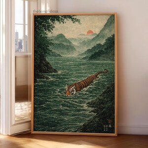 May include: A framed print depicting a tiger swimming in a river, in the style of Japanese art. The tiger has orange and black stripes. The background shows mountains, a red sun, and green foliage. The artwork is in a wooden frame.