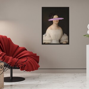 May include: A framed portrait of a woman in a white dress with a pink brushstroke covering her eyes. The portrait is hanging on a light brown wall.