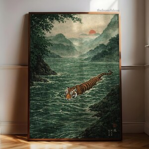 May include: Framed art print showing a tiger swimming in a river. The image features a tiger with orange and black stripes in a green river, with mountains and a red sun in the background. The style is reminiscent of traditional Japanese art.