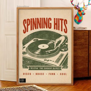 Può includere: Poster incorniciato in stile vintage con la scritta "Spinning Hits" in rosso. Il poster presenta un'illustrazione verde di un giradischi con una mano che regola il disco. Sotto, si legge "Keepin' the Groove Alive!" con generi musicali.
