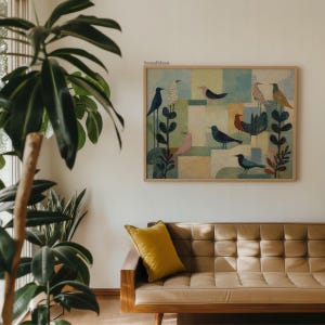May include: A framed artwork featuring stylized birds in various colors, including blue, pink, and orange, against a geometric background of muted tones. The artwork is displayed above a mid-century modern style sofa with a yellow pillow. The text "bonafidesa" is in the upper right corner.